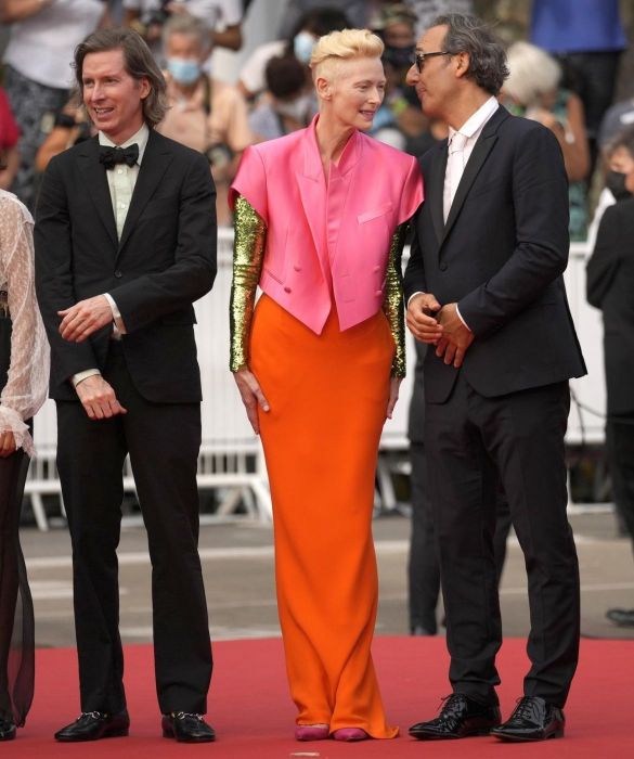 <p>Mondana, ma oltremondana: il fascino etereo di Tilda Swinton appartiene a un&rsquo;altra galassia, lo sappiamo bene. A <strong>Cannes 2021</strong> omaggia <strong>David Bowie</strong> con un look a tutto colore, in controtendenza rispetto al nero e agli altri colori "classici" imperanti: <strong>blazer cropped doppiopetto</strong> a maniche corte rosa salmone, gonna lunga arancio e lunghe maniche tempestate di paillettes dorate. Un outfit iconico, firmato <strong>Haider Ackerman</strong>.</p>
