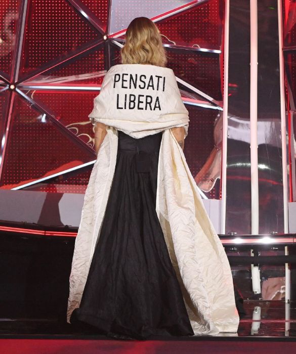 <p>Dress code: autodeterminazione. Chiara Ferragni si affaccia per la prima volta sulla scalinata dell&rsquo;Ariston girata di spalle, coperta da una stola damascata con su scritto: &ldquo;<strong>PENSATI LIBERA</strong>&rdquo;. Una <em>mise </em>che non pu&ograve; non ricordare l&rsquo;abito <em>Tax the Rich</em> sfoggiato da <strong>Alexandra Ocasio Cortez</strong> al Met Gala nel 2021. Il messaggio nasce da una conversazione tra Chiara, Maria Grazia Chiuri (direttore artistico di Dior) e l&rsquo;artista concettuale <strong>Fulvia Carnevale</strong> del duo artistico Claire Fontaine. &laquo;&ldquo;<em>Pensati libera&rdquo; &egrave; dedicato a tutte le donne che hanno voglia di sentirsi semplicemente loro stesse senza essere giudicate</em>&raquo;, ha spiegato Ferragni su Instagram.</p>
