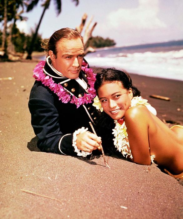 <p>Marlon Brando in una scena de <em>Gli ammutinati del Bounty</em>, insieme alla futura moglie Tarita Teriipia. I due si conobbero sul set e si sposarono l&rsquo;anno successivo: la coppia ebbe due figli e visse sull&rsquo;isola di Tetiaroa, di propriet&agrave; dell'attore, fino al divorzio avvenuto nel 1972.</p>
